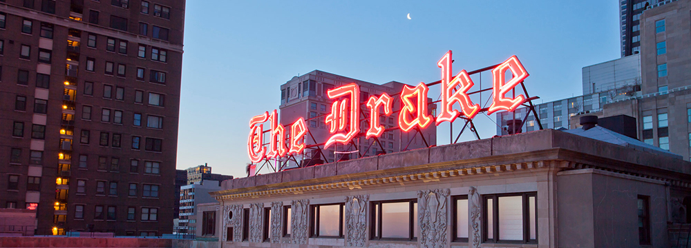photo of the rooftop sign for the Drake Hotel in Chicago, lit up in red letters